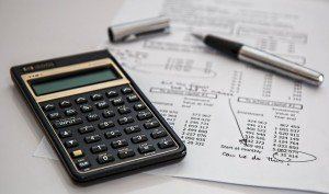 Calculator and pen resting on a printed budget sheet