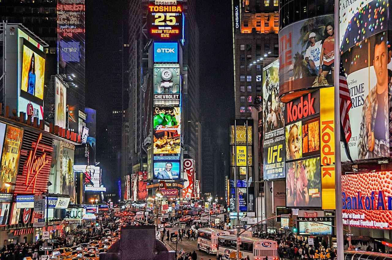 Times Square in New York at night, covered in illuminated brand advertising