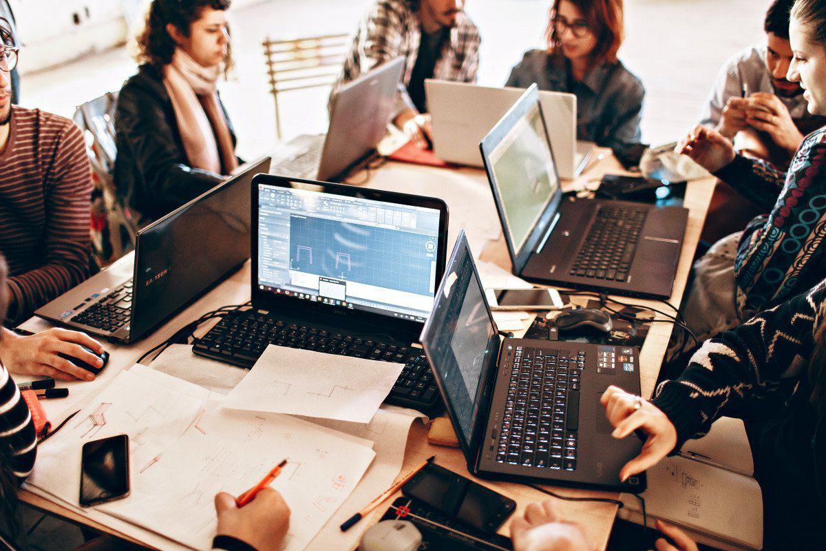 Group of people working together around laptops